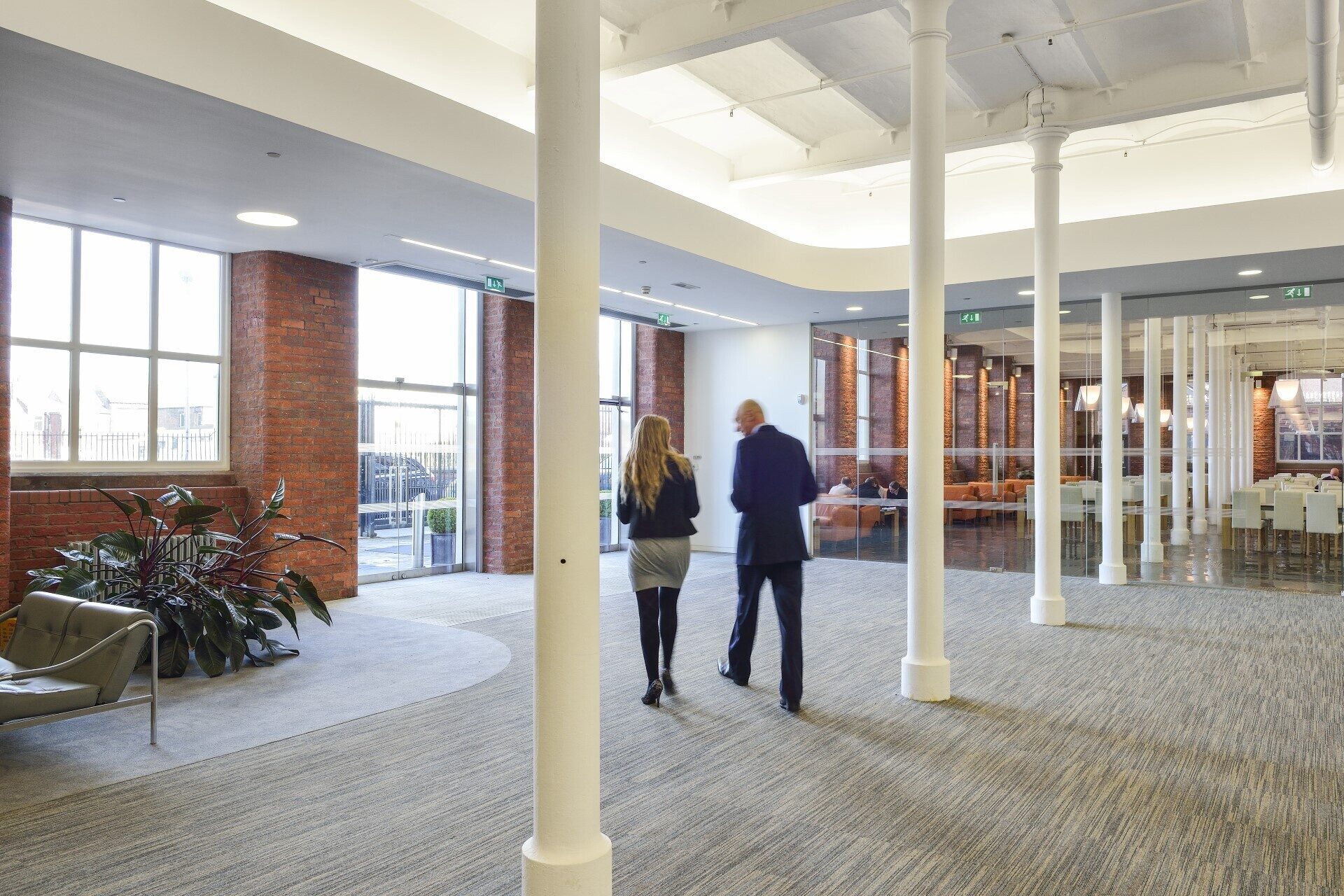 Two people walking across the reception area at Lowry Mill
